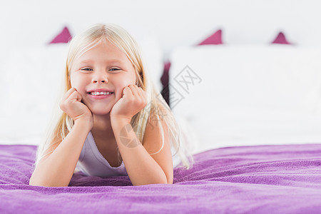 小女孩躺在双人床上图片