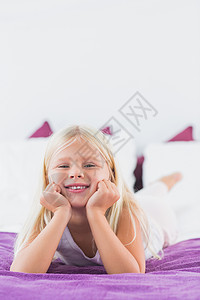 小女孩睡在床上说谎金发女孩紫色浅色枕头女性长发金发女郎羽绒被图片