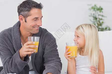 父亲和他的女儿 喝杯橙汁的果汁图片