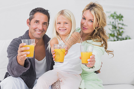 家庭拿着橙汁杯子图片