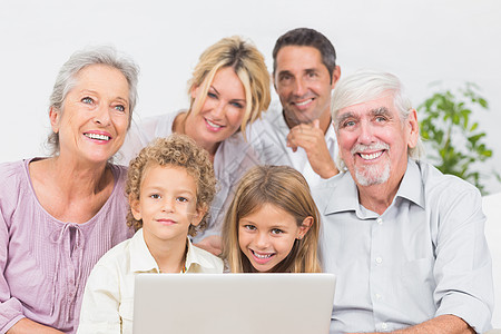 家庭在笔记本电脑屏幕前微笑图片