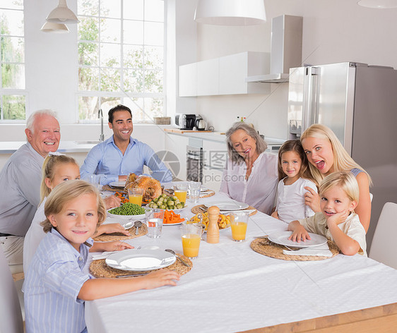 幸福的一家人去吃饭了儿子祖父母父母住所火鸡微笑女孩大家庭桌子公寓图片