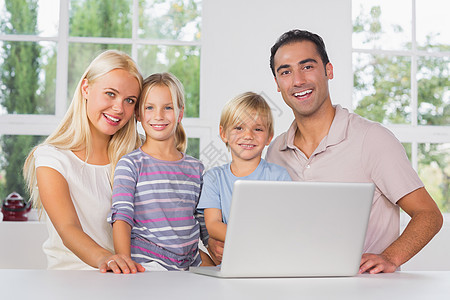 幸福家庭一起用笔记本电脑男人厨房女孩技术棕色父亲柜台男性母亲快乐图片