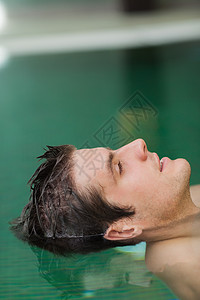 放松的人漂在游泳池里图片