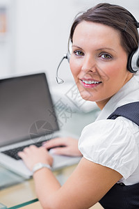 佩戴头盔和使用笔记本电脑的商业妇女肖像代理人中心沟通技术女性女士桌子服务商务棕色图片