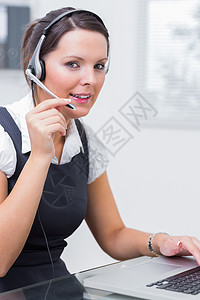 在服务台使用膝上型电脑时佩戴头盔的女性行政主管技术呼叫头发人士桌子沟通操作员中心商务女士图片