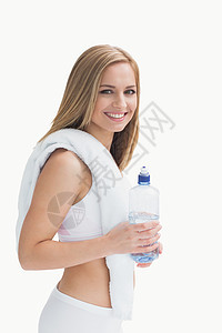 微笑的年轻女人的肖像 脖子上带着毛巾 拿着水瓶图片