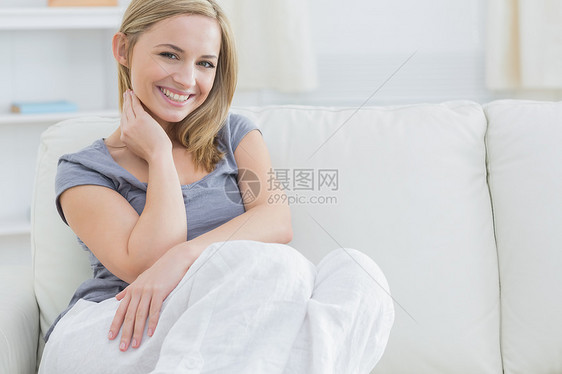 坐在沙发上的放松女人的肖像家庭生活房子头发浅色金发闲暇长椅女性客厅女士图片