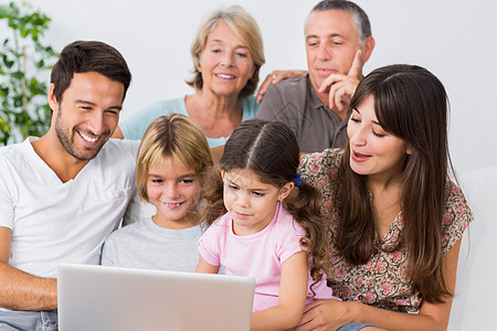 微笑的家庭在看笔记本电脑上的东西图片