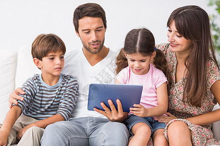 幸福的家庭看平板电脑触摸屏女儿男生女士母亲父亲混血儿子棕色女孩图片