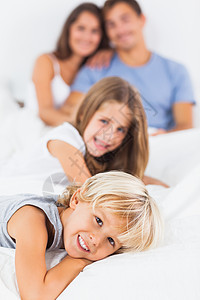 躺在床上的微笑儿童男人拥抱儿子男生女儿睡衣金发女郎羽绒被男性父亲图片