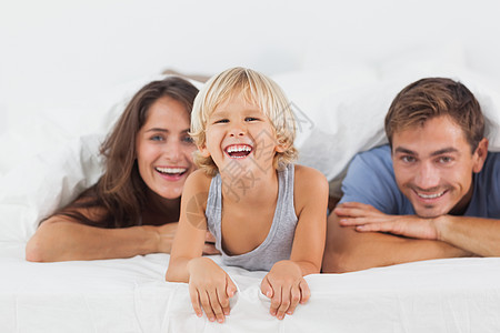 幸福的一家人一起躺在床上卧室男性父亲长发男生感情头发棕色金发儿子图片