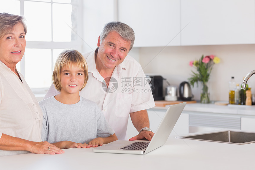 孩子们和祖父母用笔记本电脑在前面看镜头图片