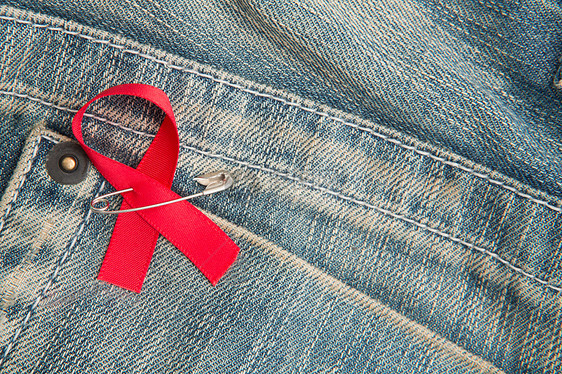 紧贴在牛仔裤上的艾滋病宣传丝带红色疾病三物机构世界别针牛仔布图片