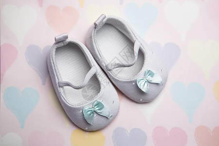 心脏模式背景的婴儿蓝皮鞋图片