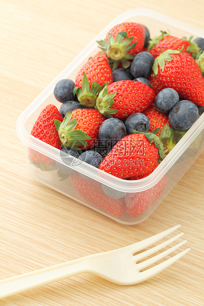 塑料容器中的草莓和蓝莓混合浆果小吃叶子桌子盒子木头饮食午餐饭盒食物图片