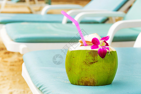 椰子 在沙滩长椅上喝稻草的椰子图片