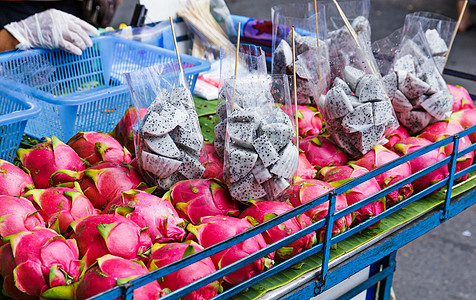 龙果在泰国市场摊位上街头市场街道红色食物水果摊图片