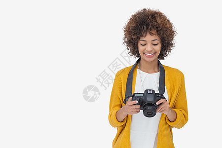 女人看着她的数码相机 笑着微笑图片