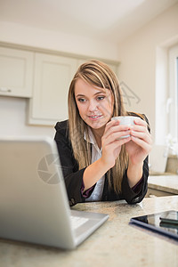 妇女一边喝咖啡一边忙着多媒体工作的妇女图片
