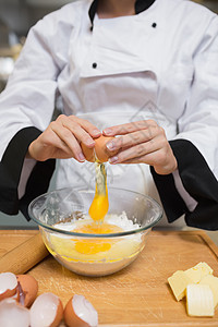 厨师将鸡蛋破碎成面粉图片