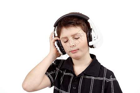 一个快乐的小男孩的肖像 用耳机收听音乐童年青少年黑色白色衬衫男生幸福男性卡拉ok技术图片