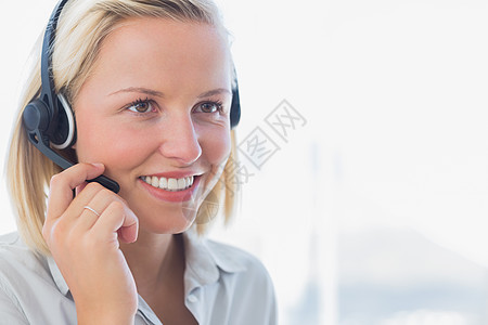 商业女商务人士在耳机上说话图片