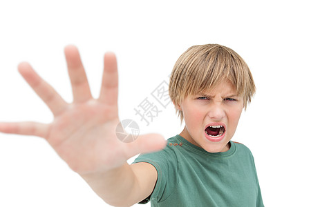 愤世嫉俗的小男孩大喊大叫 手举手作停止标志图片