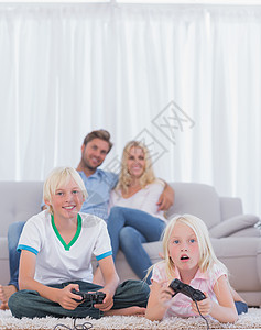 儿童在父母期间玩电子游戏的地毯上的儿童a图片