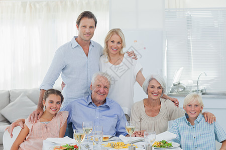 大家庭在晚餐桌前微笑的笑容图片