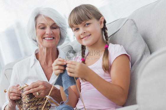 年轻女孩和孙女一起织毛衣图片