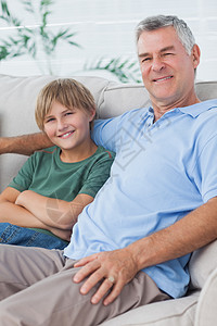 孙子和祖父的肖像坐在沙发上图片