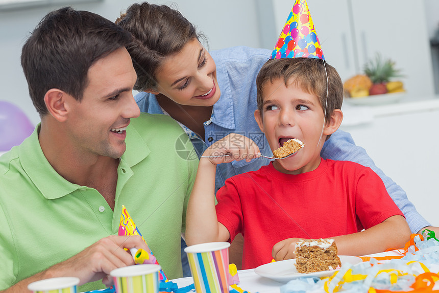 和父母一起吃生日蛋糕的小男孩图片