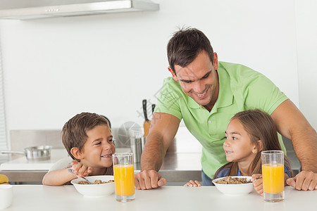 父亲在孩子吃早饭时和他们的孩子聊天图片