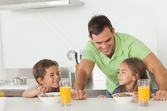 父亲在孩子吃早饭时和他们的孩子聊天图片