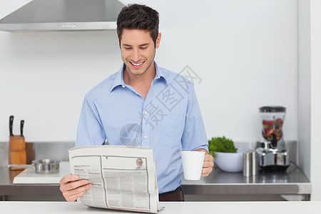 男人在厨房看报纸的时候柜台住所快乐家庭咖啡阅读微笑男性房子杯子图片