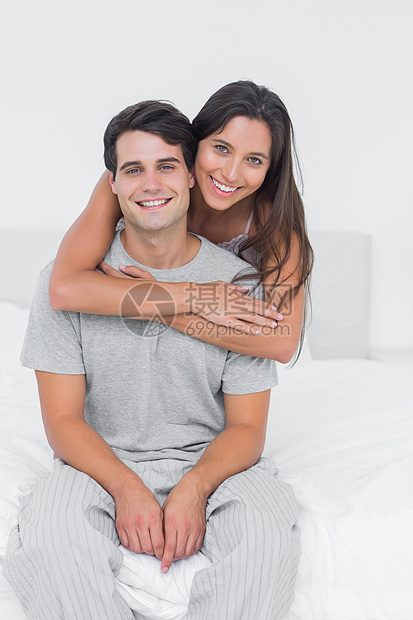拥抱其伴侣的妇女坐在床上图片