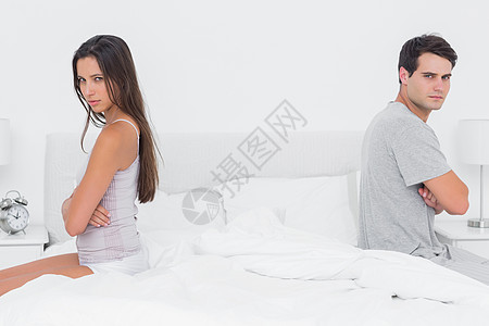 坐着双手的情侣 交叉背对背躺在床上图片
