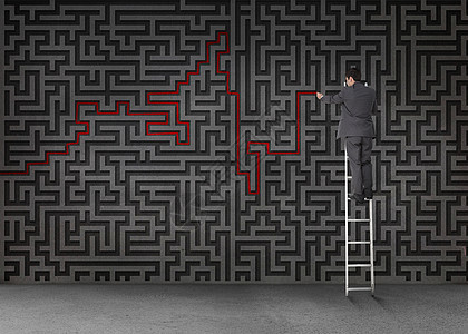 商务人士站在梯子上 通过黑迷宫画一条红线图片