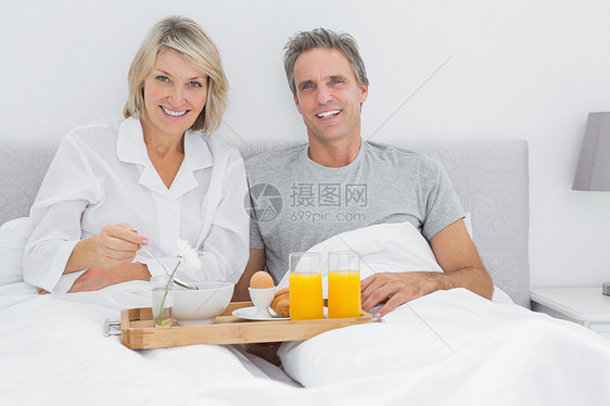 幸福的情侣在床上吃早餐家庭女性男人夫妻房子微笑感情谷物男性卧室图片