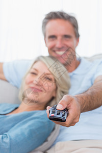 在家看电视时开心的一对情侣放松公寓娱乐性女士电视夫妻男人感情住所享受频道图片