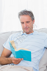 男人用书在沙发上放松图片