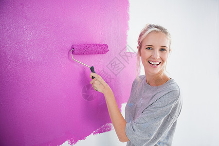 笑着女人用粉红色的画在墙上图片