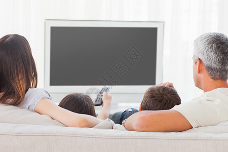 一家人坐在沙发上一起看电视图片