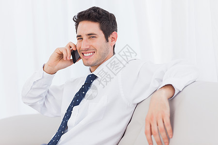商务人士用手机在沙发上打来电话图片