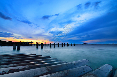 海中有桥柱的日落天空建筑海景海浪旅行夕阳戏剧性天空季节休息场景图片