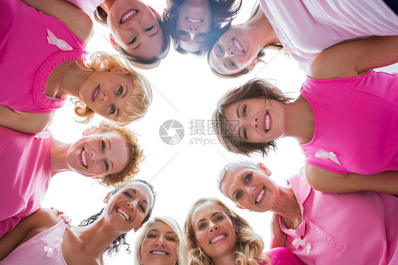 穿着粉红色乳癌粉色衣着的圆圈中快乐愉快的妇女图片