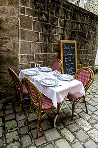 在法国中世纪大厦前的餐厅桌前吃饭图片
