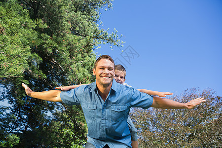 和他父亲玩耍的孩子蓝色阳光快乐感情公园男性儿子乐趣亲密感农村图片
