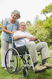 与伴侣一起坐在轮椅上微笑的成年男子图片